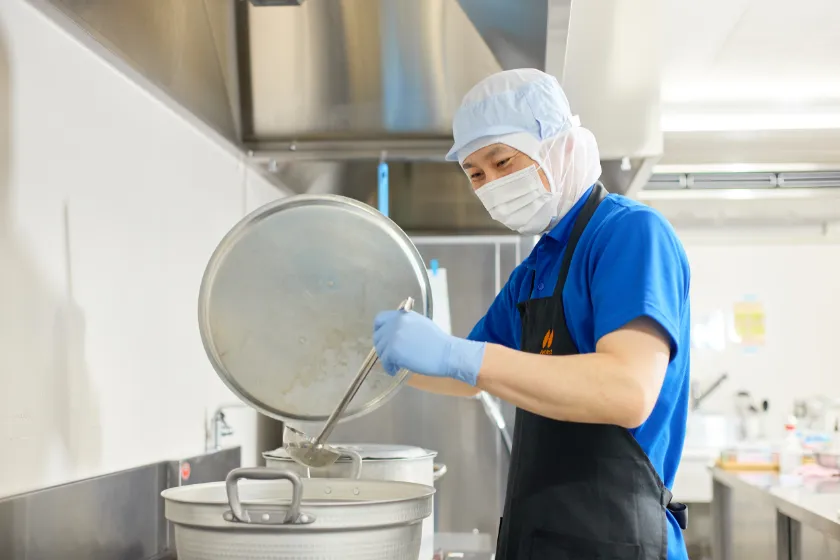 お玉を持って調理中の様子