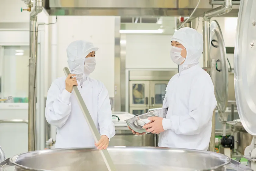 調理スタッフが作業場で鍋をかき混ぜている様子